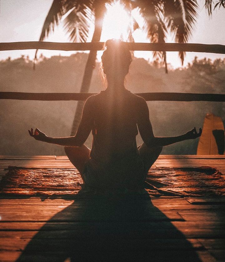 Persona meditando al atardecer
